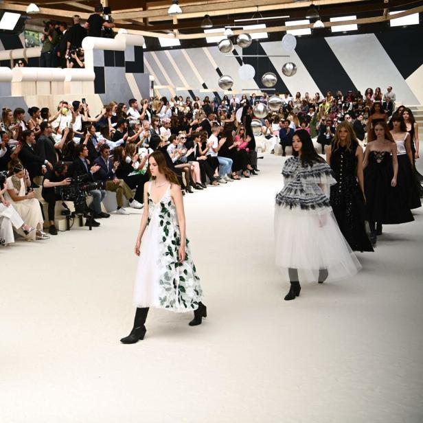 Models präsentieren Mode auf dem Laufsteg vor einem Publikum.