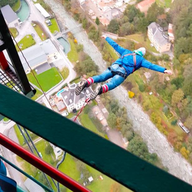 Eine Person springt mit einem Bungeeseil von einer hohen Brücke.