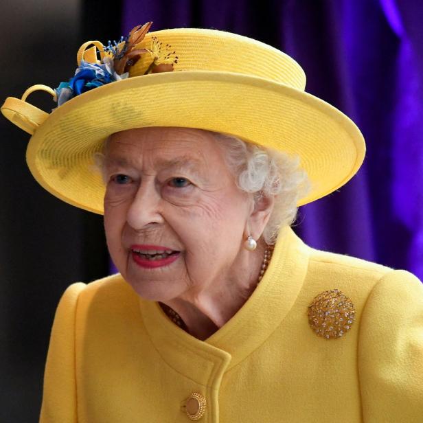 Königin Elisabeth II. trägt einen gelben Hut und ein gelbes Kostüm.