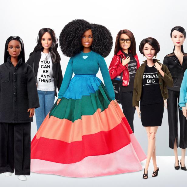 Eine Reihe von Barbie-Puppen in verschiedenen Outfits stehen nebeneinander.