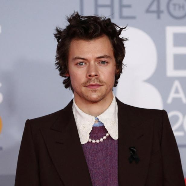 Harry Styles bei den Brit Awards 2020 in einem braunen Anzug mit Perlenkette.