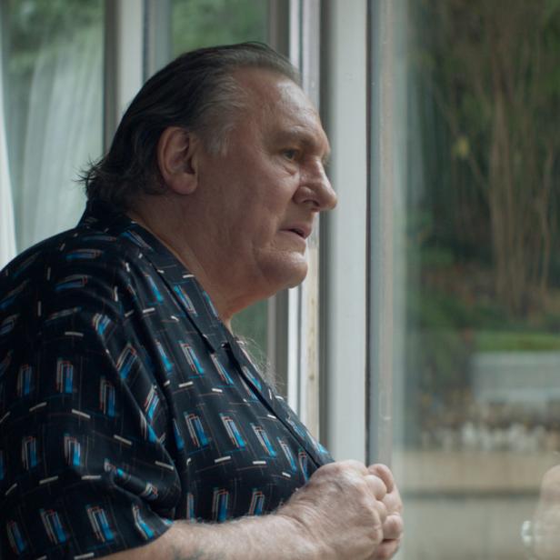 Gérard Depardieu blickt aus dem Fenster.