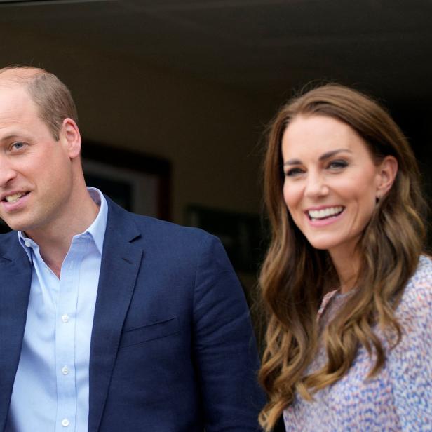 Prinz William zeigt mit dem Finger, während Kate Middleton daneben lächelt.