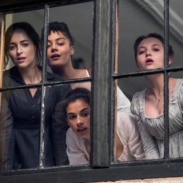 Vier Frauen schauen aus einem Fenster.
