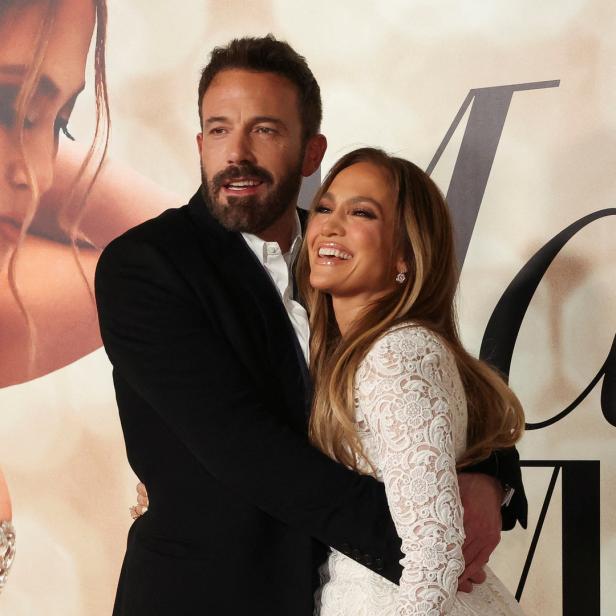 Jennifer Lopez und Ben Affleck posieren vor einem Poster für ihren Film „This Is Me… Now: A Love Story“.