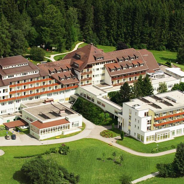 Luftaufnahme eines großen Hotels mit mehreren Gebäuden inmitten einer grünen Landschaft.