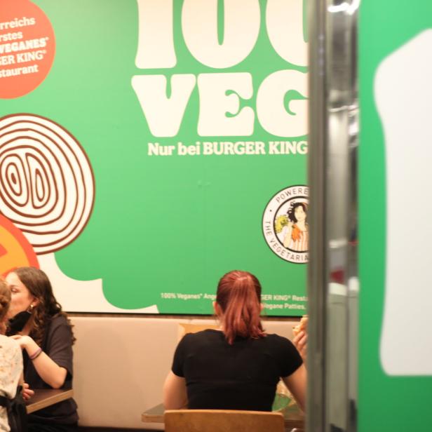 Gäste sitzen in einem Burger King Restaurant mit veganem Angebot.