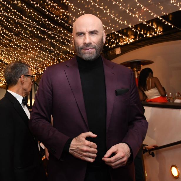 John Travolta bei einer Veranstaltung in einem violetten Anzug.