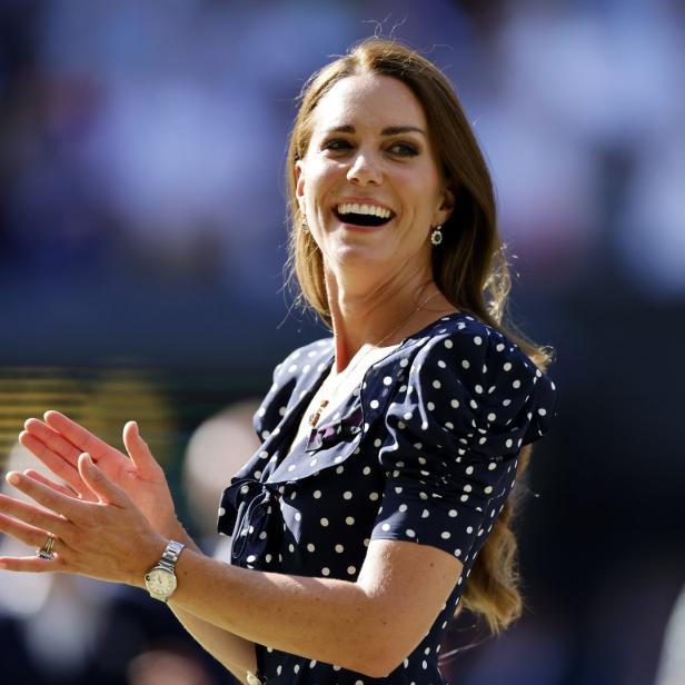 Kate Middleton klatscht in einem blau-weiß gepunkteten Kleid.