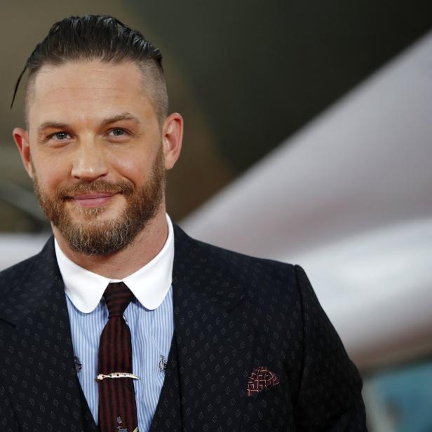Porträt von Tom Hardy in einem dunklen Anzug mit Hemd und Krawatte.