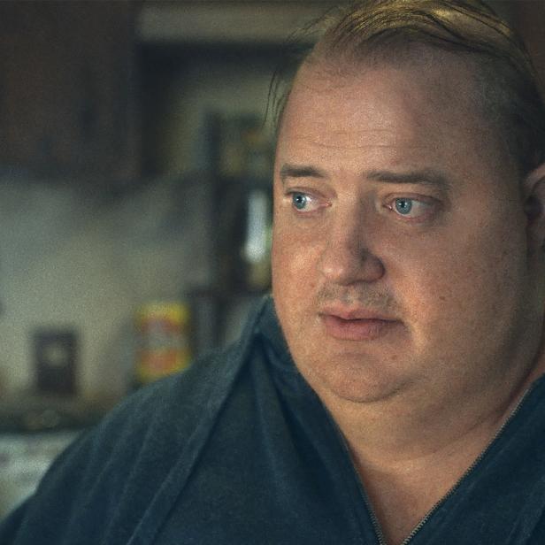 Ein Porträt von Brendan Fraser mit blauem Sweatshirt vor unscharfem Hintergrund.