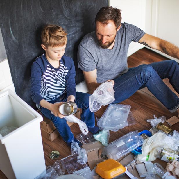 Mülltrennung: Vater und Sohn sortieren Abfälle zu Hause.