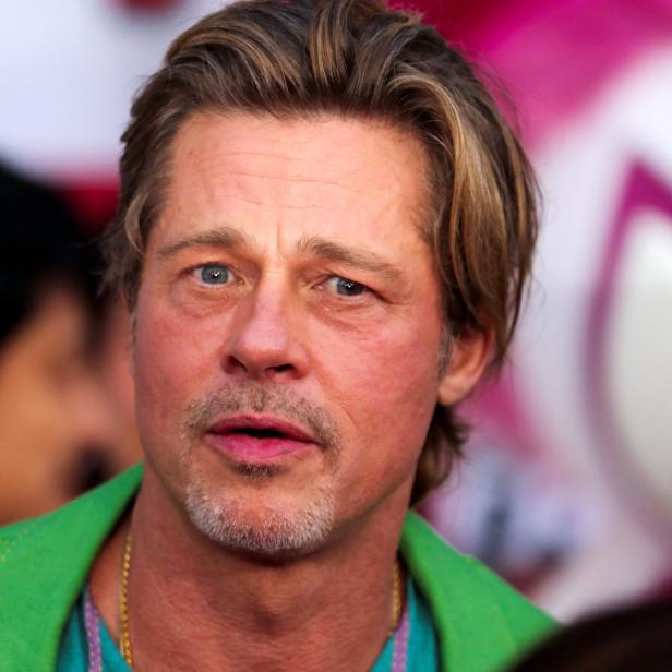 Porträt von Brad Pitt mit blonden Haaren und einem grünen Jackett.