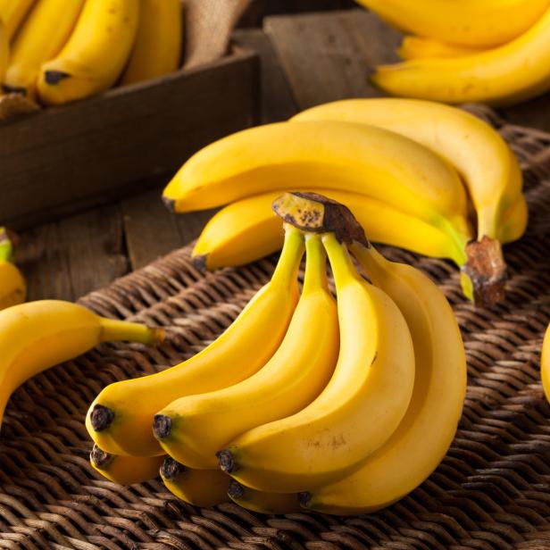 Ein Bund reifer Bananen liegt auf einem geflochtenen Untergrund.