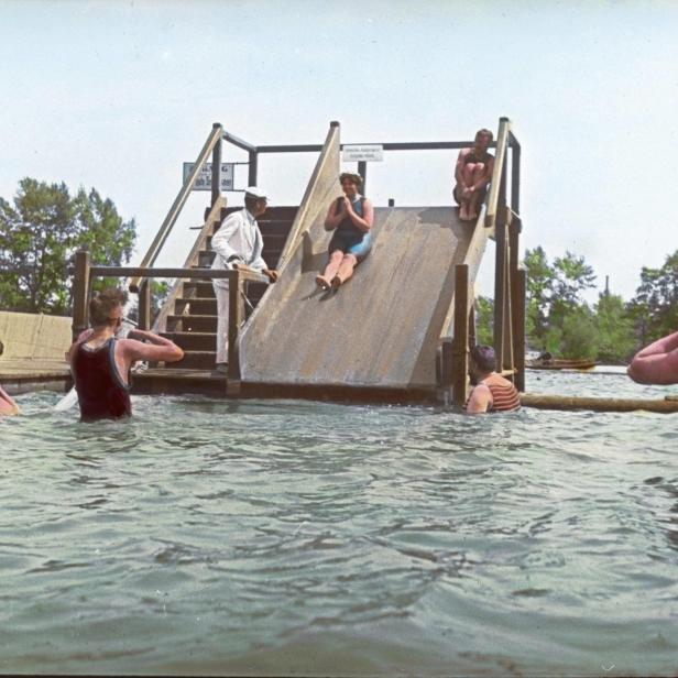 Menschen vergnügen sich auf einer Wasserrutsche in einem Freibad.