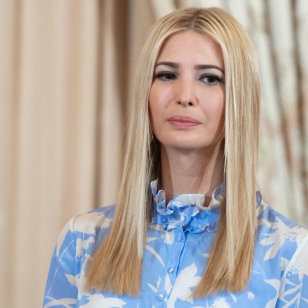 Ivanka Trump in einem blau-weißen Kleid vor einem Vorhang.