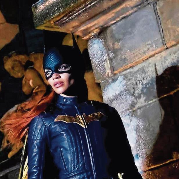 Batgirl im blauen Lederkostüm mit gelbem Umhang und Fledermaus-Symbol.