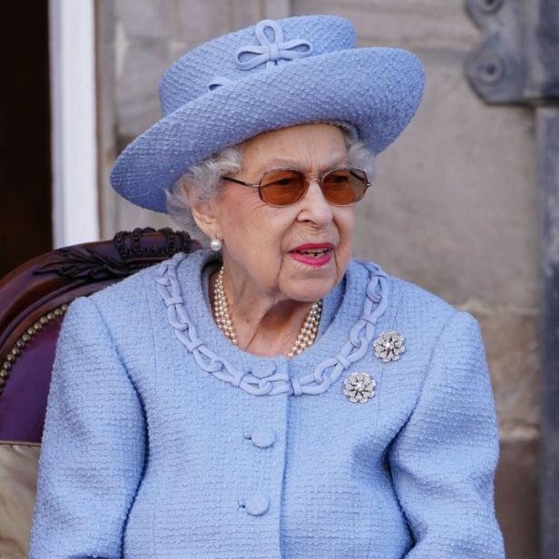Königin Elisabeth II. in einem hellblauen Kostüm und Hut.