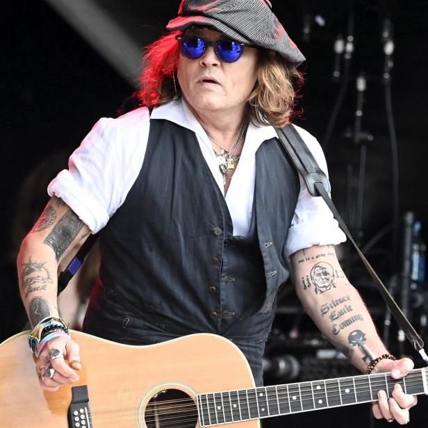 Johnny Depp spielt Gitarre bei einem Auftritt.