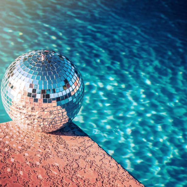 Eine Discokugel liegt am Rand eines Schwimmbeckens.