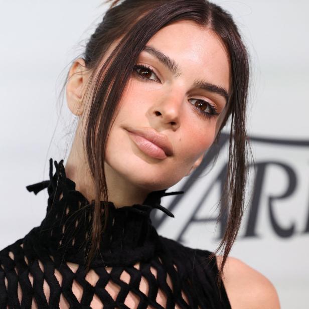 Emily Ratajkowski posiert in einem schwarzen Kleid mit Rollkragen.