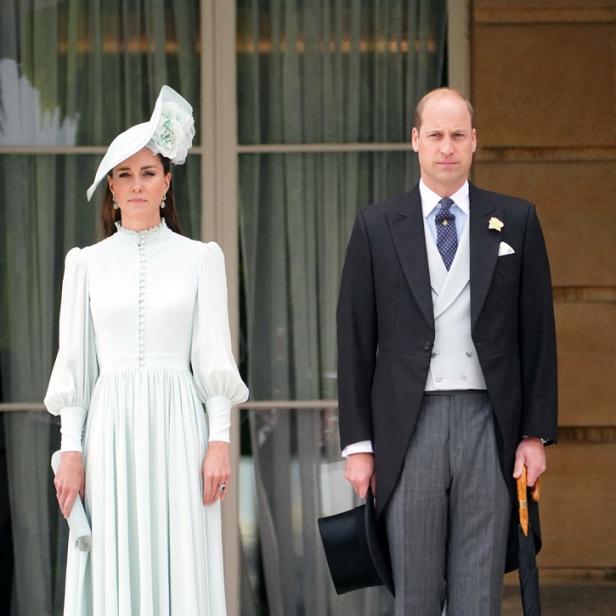 Prinz William und Prinzessin Kate stehen formell gekleidet vor einem Gebäude.