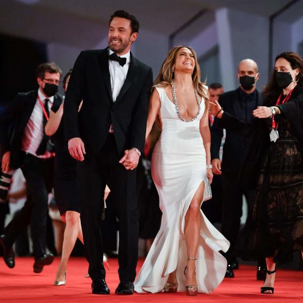 Jennifer Lopez und Ben Affleck gehen Händchen haltend über einen roten Teppich.