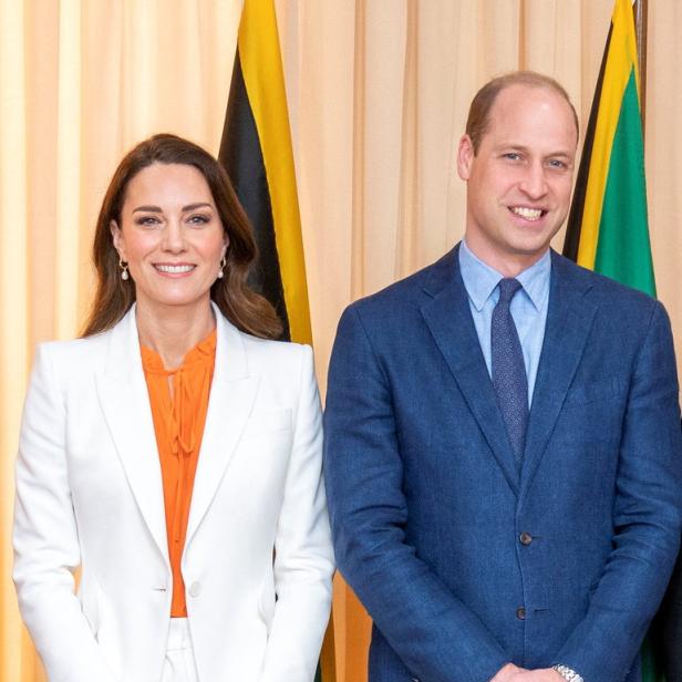 Prinz William und Prinzessin Kate posieren vor der jamaikanischen Flagge.