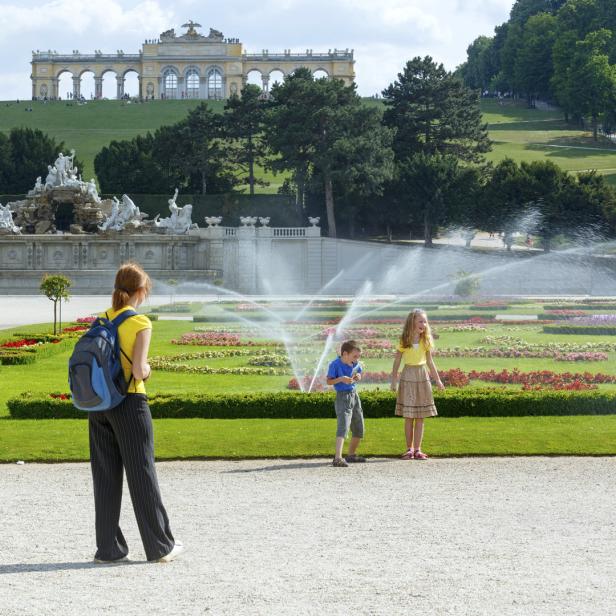 Kinder spielen im Garten von Schloss Schönbrunn in Wien.