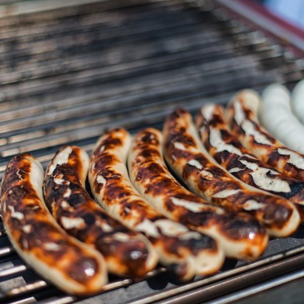 Verschiedene Würste liegen auf einem Grill.