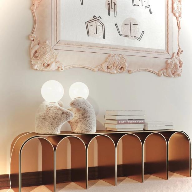 Zwei Teddybär-Lampen stehen auf einem Tisch unter einem gerahmten Bild mit Strichzeichnungen.