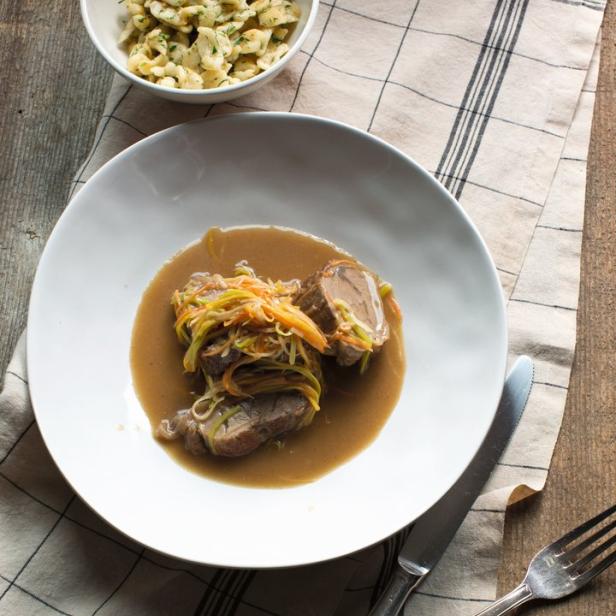 Ein Teller mit Rinderrouladen in Soße, dazu Spätzle.