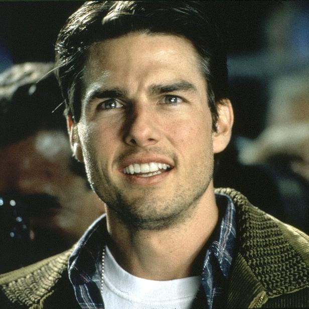 Porträt von Tom Cruise auf einer Veranstaltung mit Fotografen im Hintergrund.