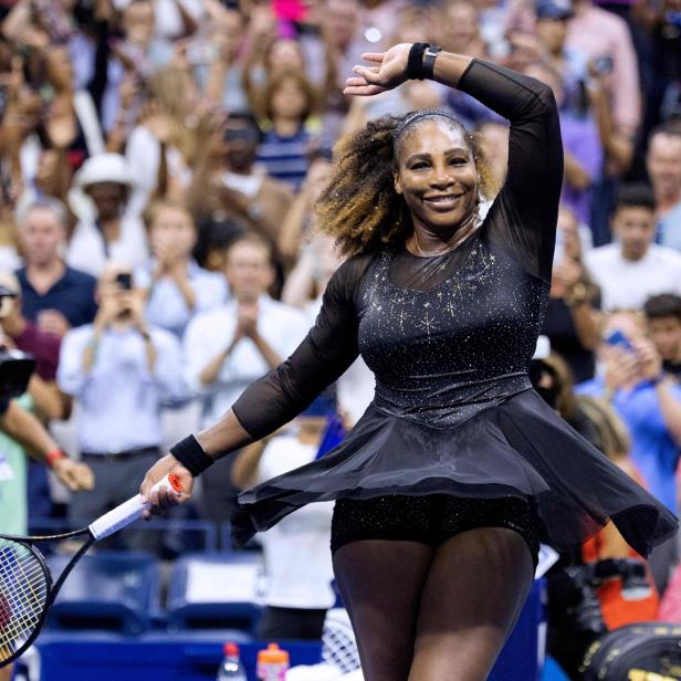 Serena Williams jubelt mit erhobenem Arm vor einer jubelnden Zuschauermenge.
