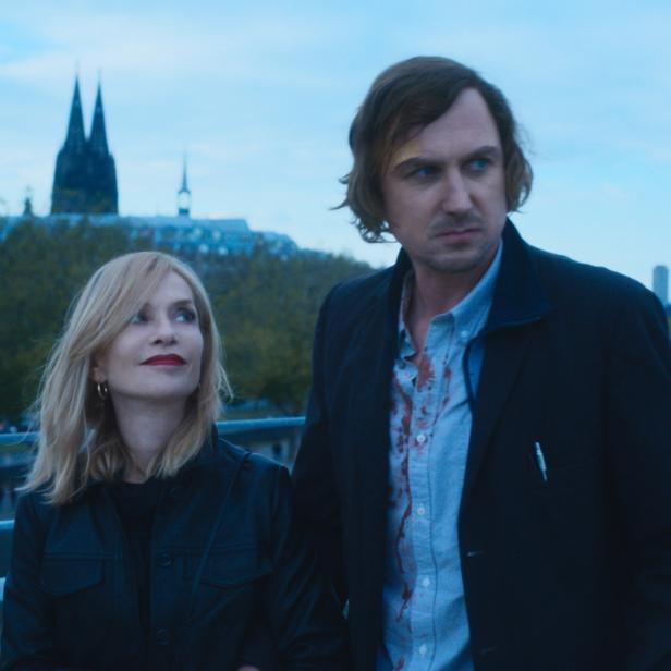 Isabelle Huppert und Lars Eidinger stehen vor dem Kölner Dom.
