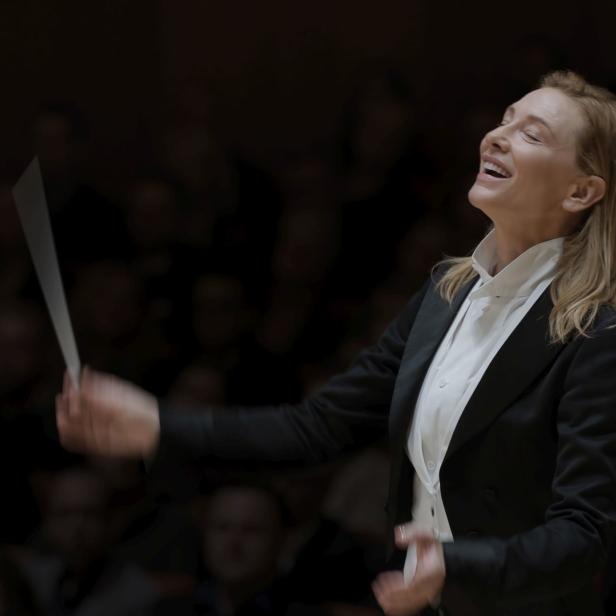 Eine Dirigentin leitet ein Orchester mit einem Taktstock.