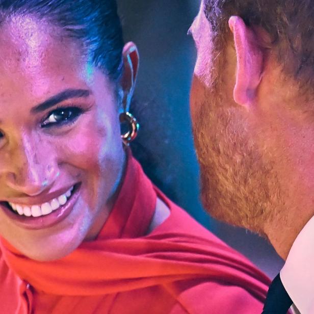 Meghan Markle lächelt Prinz Harry zu.