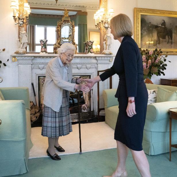 Königin Elizabeth II. schüttelt Liz Truss in einem Wohnzimmer die Hand.