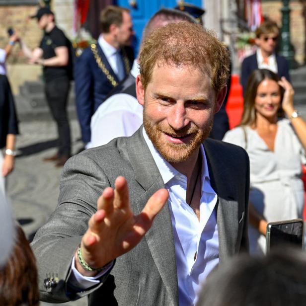 Prinz Harry winkt einer Menschenmenge zu.