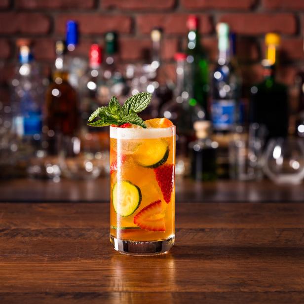 Ein Glas mit einem alkoholfreien Getränk, dekoriert mit Erdbeeren, Gurken und Minze.