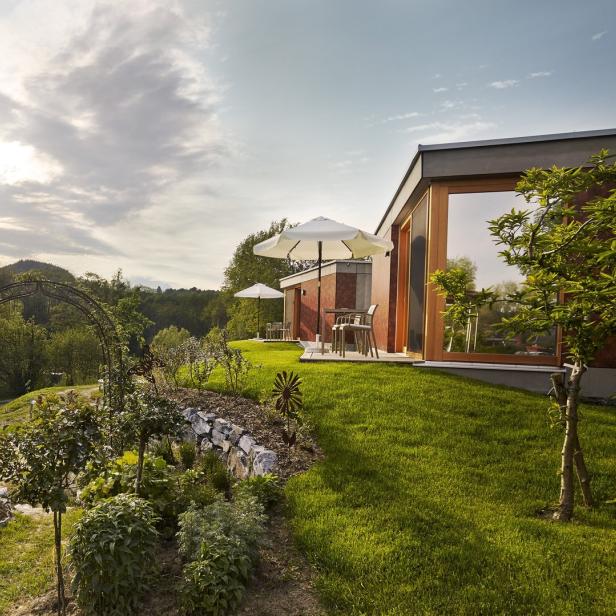 Ein Garten mit einem Weg, der zu modernen Gebäuden mit Terrassen führt.