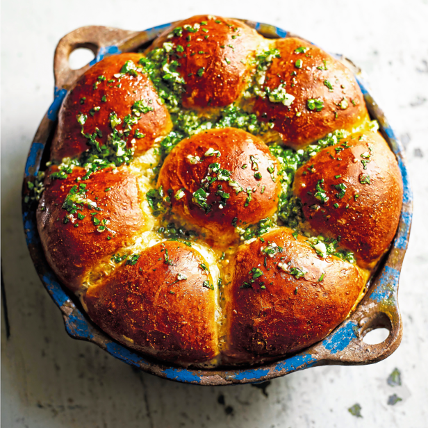 Ein Zupfbrot mit Kräutern in einer blauen Form.