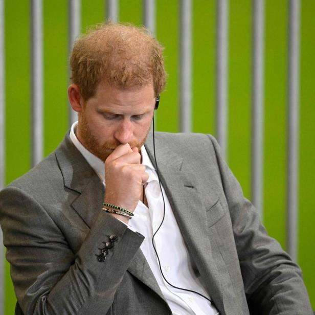 Prinz Harry mit einem Headset, in Gedanken versunken.
