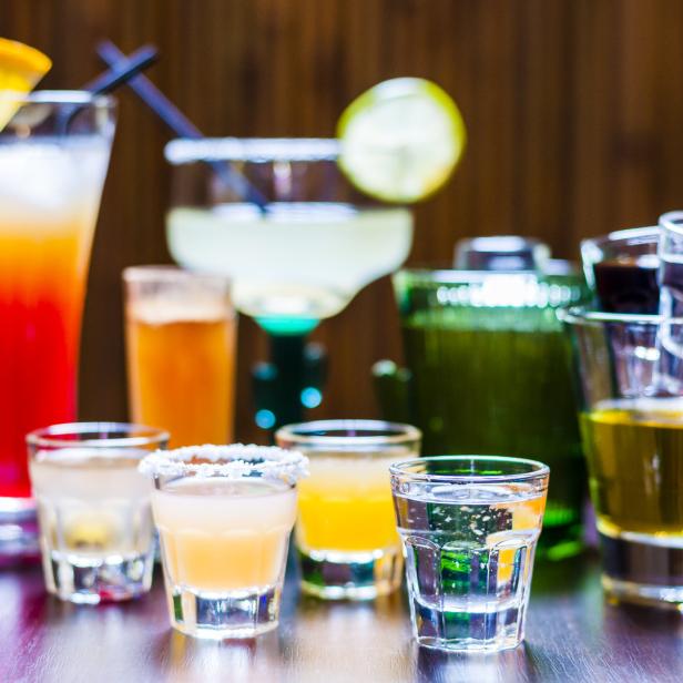 Verschiedene Cocktails und Schnapsgläser stehen auf einem Tisch.