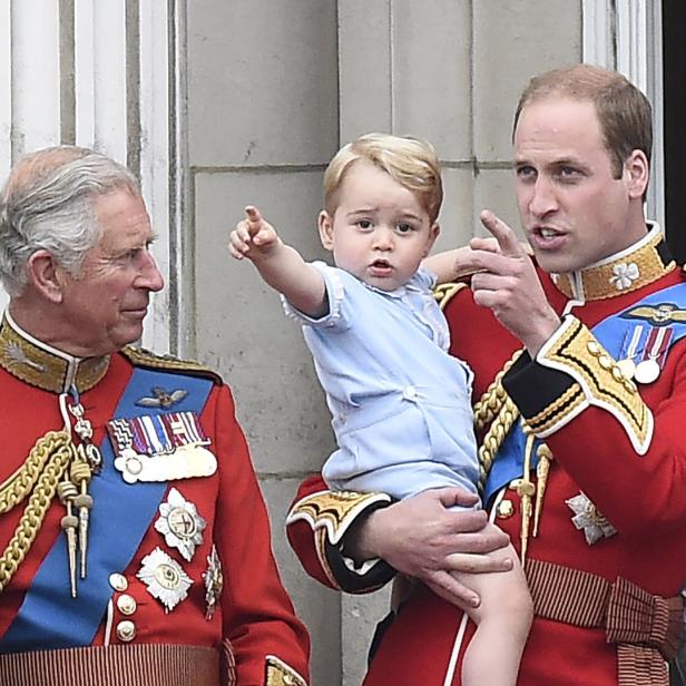 König Charles, Prinz George und Prinz William zeigen in die Ferne.