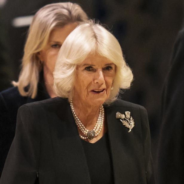 Königin Camilla trägt eine Perlenkette und eine Distelbrosche.