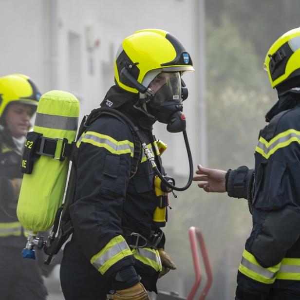 Mehrere Feuerwehrleute mit Atemschutzgeräten im Einsatz.