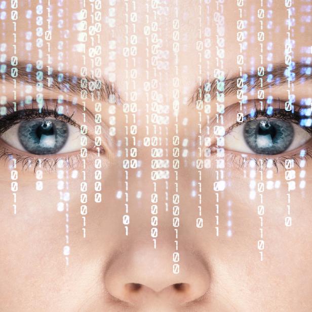 Das Gesicht einer Frau mit binärem Code, der auf ihr Gesicht projiziert wird.