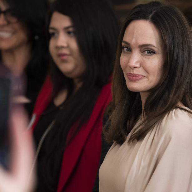 Angelina Jolie bei einer Veranstaltung, umgeben von anderen Personen.