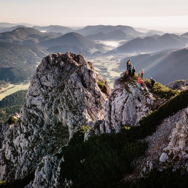 Wanderer genießen die Aussicht von einem felsigen Gipfel in den Wiener Alpen bei Puchberg.